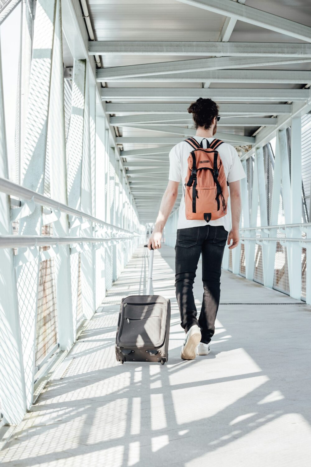 旅行鞄を持って歩く男性